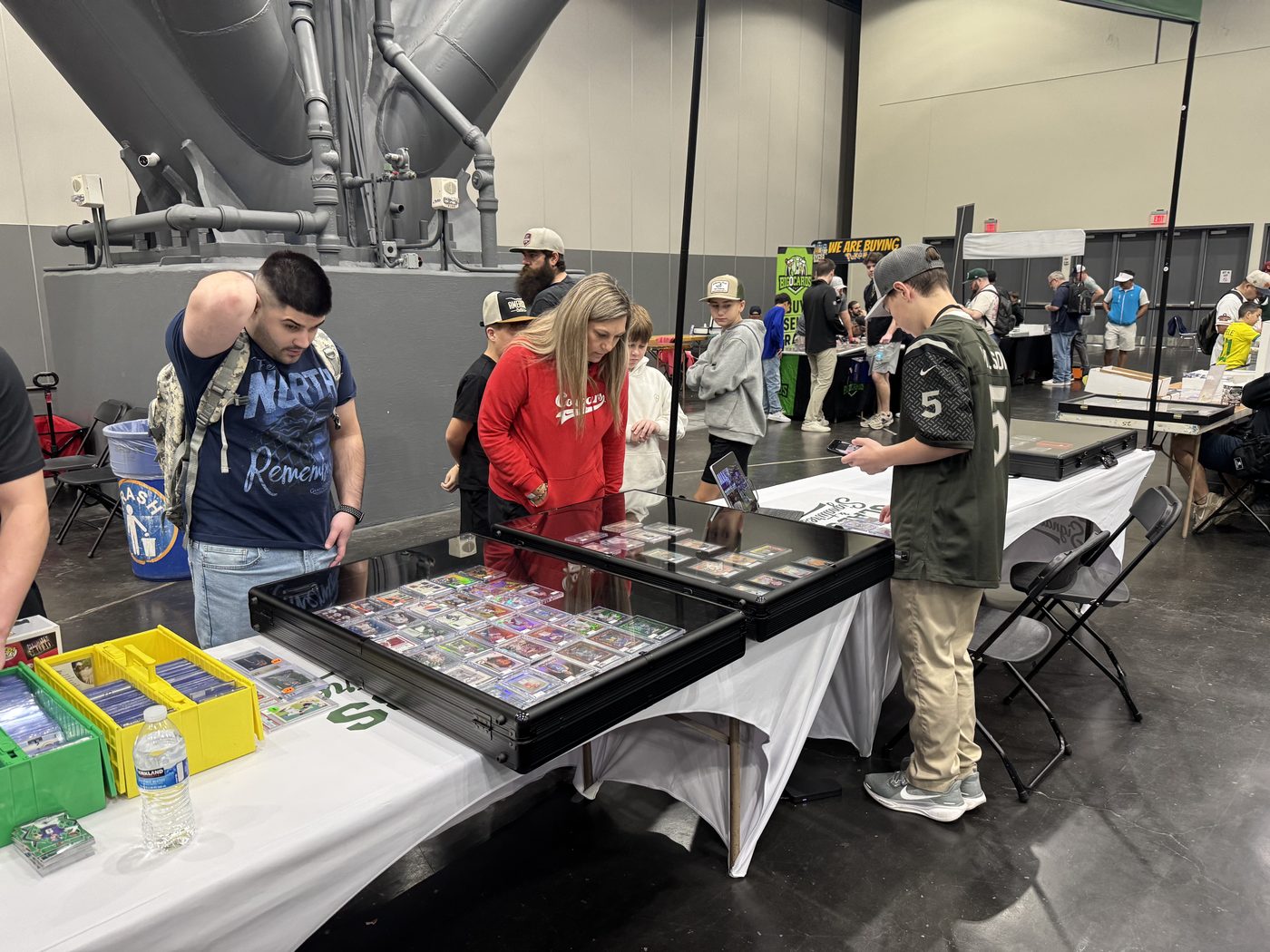 Collectors browsing the Slabs & Signatures cases at the H-Town Card Show in the George R. Brown Convention Center, January 2026, with Grayson working the table