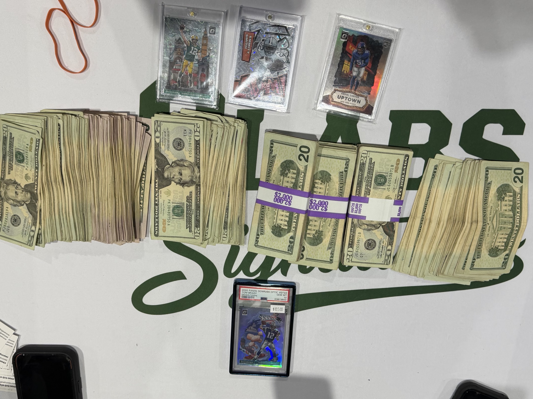 Stacks of cash and graded cards from sales at the H-Town Card Show, March 2026