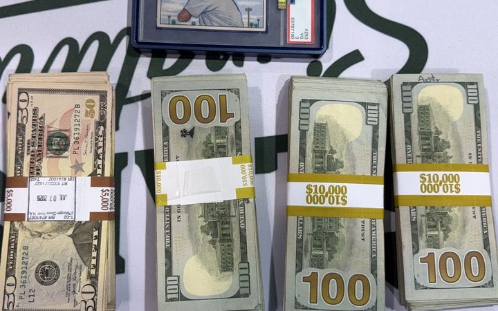 1951 Bowman Mickey Mantle rookie card next to banded cash stacks from the largest cash sale at the West Coast Card Show in Anaheim, July 2026